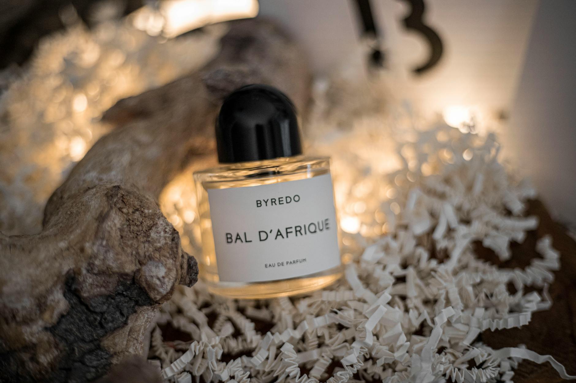 Perfumy Byredo Bal D’Afrique ustawione wśród złożonych kartek