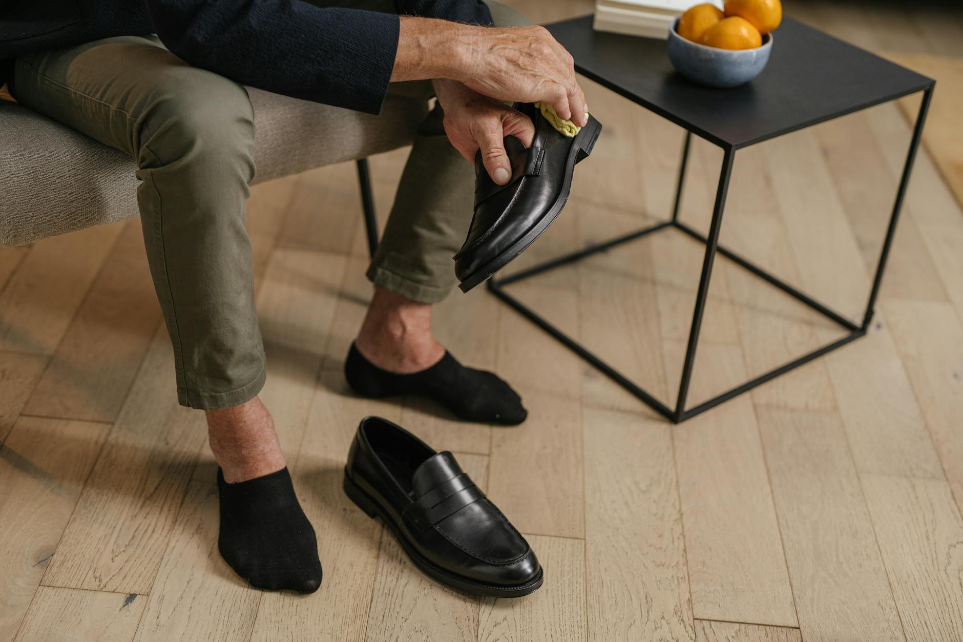 Starsza osoba czyści czarne skórzane buty w domu