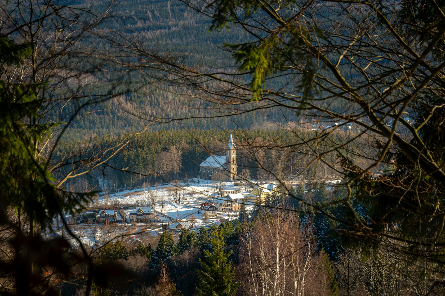 Zimowy pejzaż Szklarskiej Poręby z kościołem na tle ośnieżonego lasu