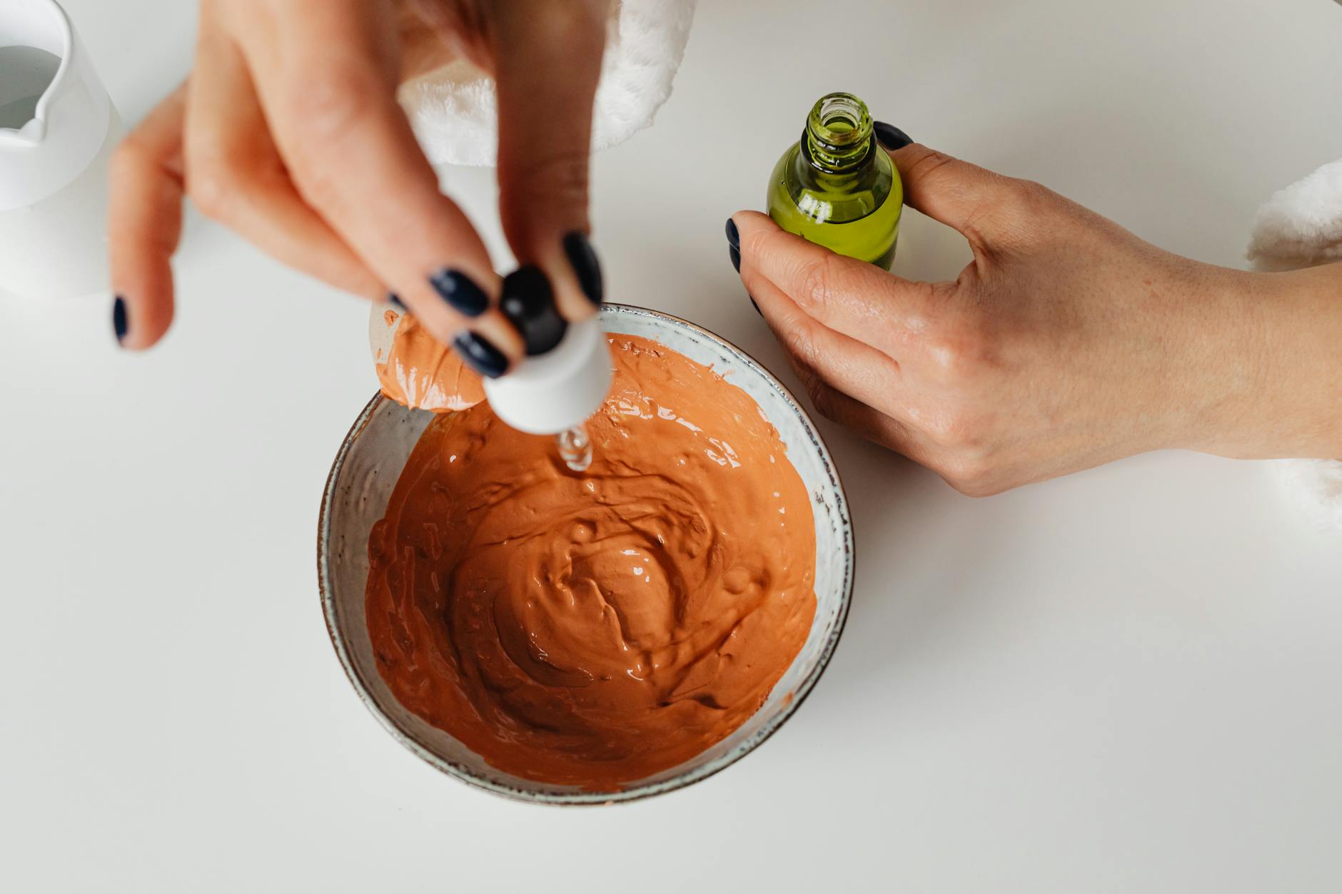 Dłonie mieszające naturalną mieszankę w miseczce w minimalistycznym wnętrzu