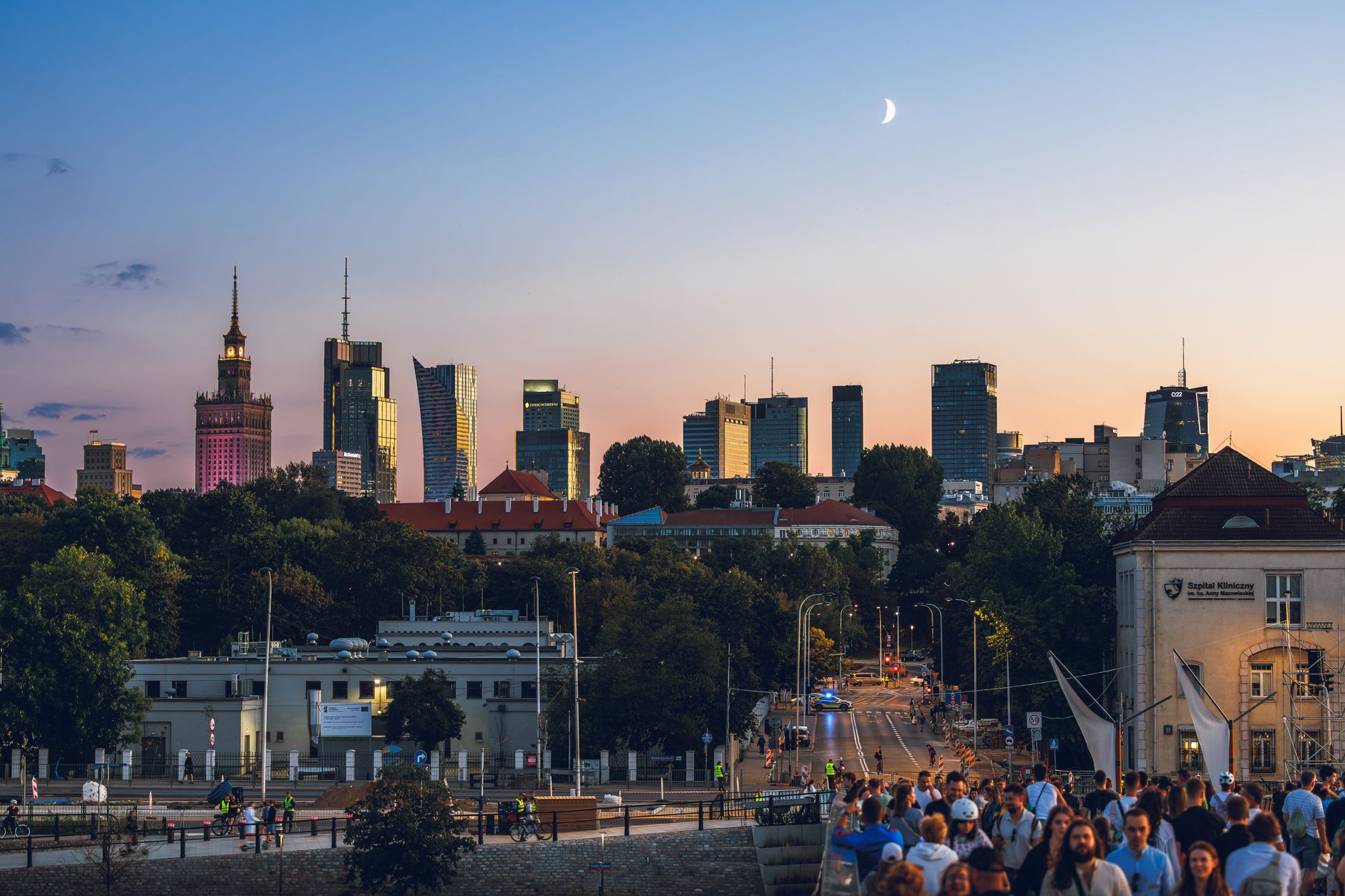 Warszawska panorama o zachodzie słońca z wieżowcami i ruchliwym mostem
